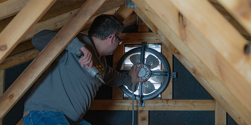 Man installing attic fan